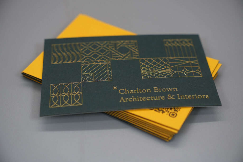 Luxury duplex business cards with gold foil detailing and geometric patterns, printed on premium thick cardstock