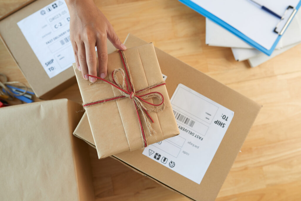 A wrapped parcel with labelled shipping boxes, showcasing direct mail fulfilment, packaging, distribution and mailing services for business campaigns