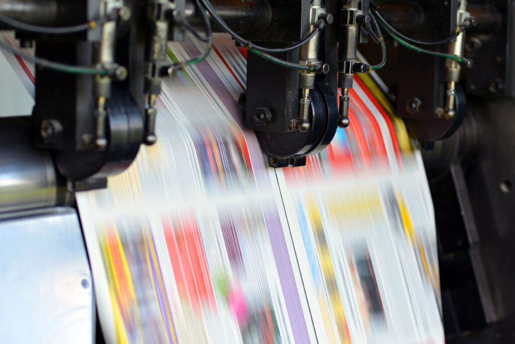 High-speed commercial printing press producing full-colour printed sheets, showcasing web-to-print services, digital workflow automation and premium print production