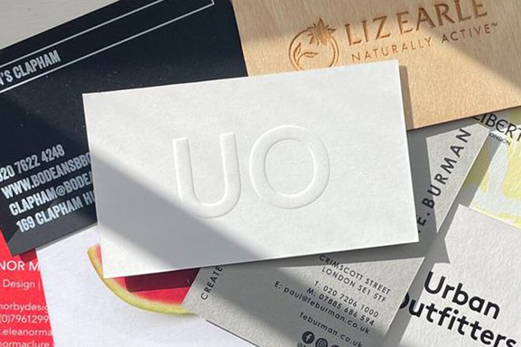 White business card with blind embossing showcased among premium printed cards and specialty print finishes