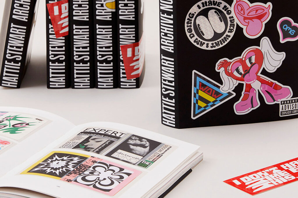 Collection of custom printed hardcover art books with an open book displaying high-quality interior page printing