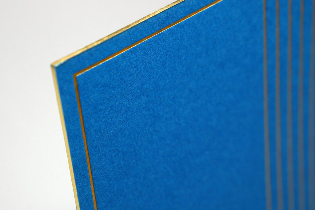Detailed view of triplex board showcasing a metallic gold edge and smooth blue surface