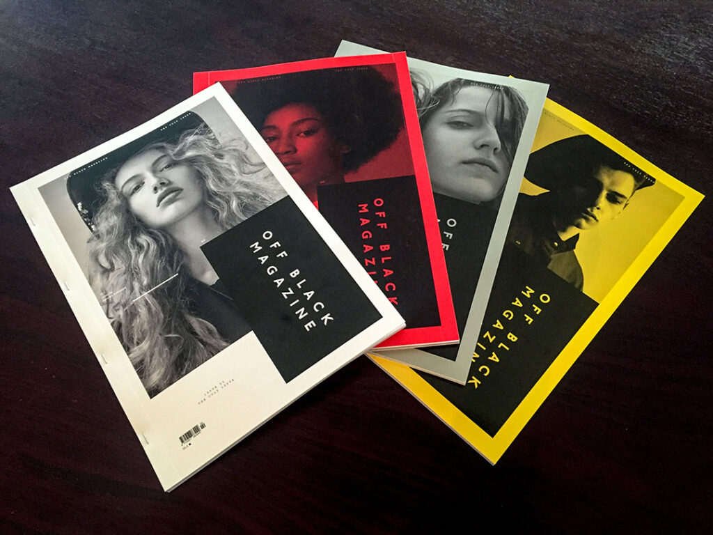 Printed magazines with vibrant cover designs and saddle-stitched binding displayed together